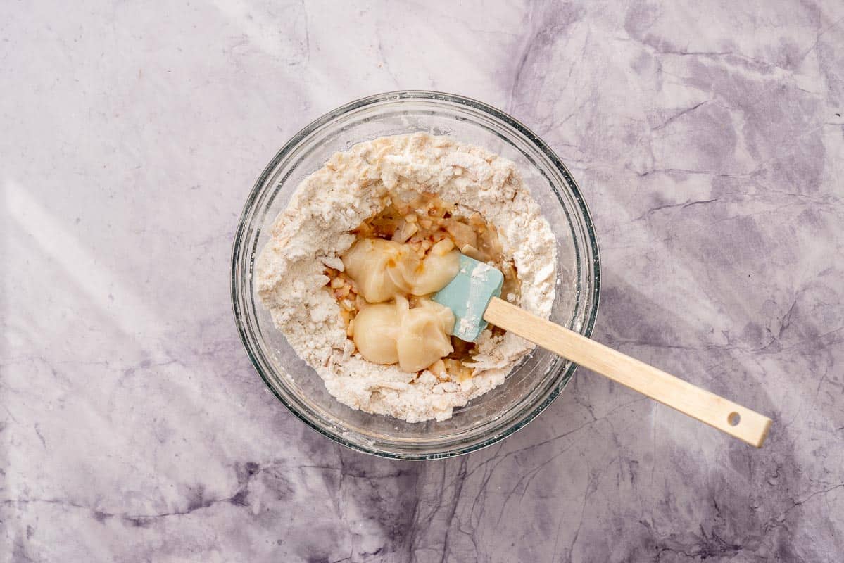 All the ingredients in a bowl with a spatula on the bench