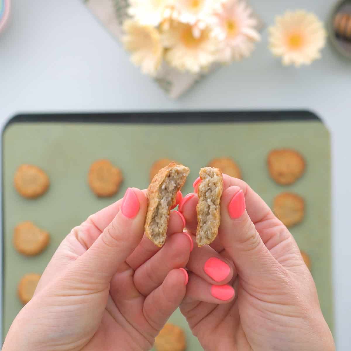 A cookie broken in half to show the soft banana and oat filing.