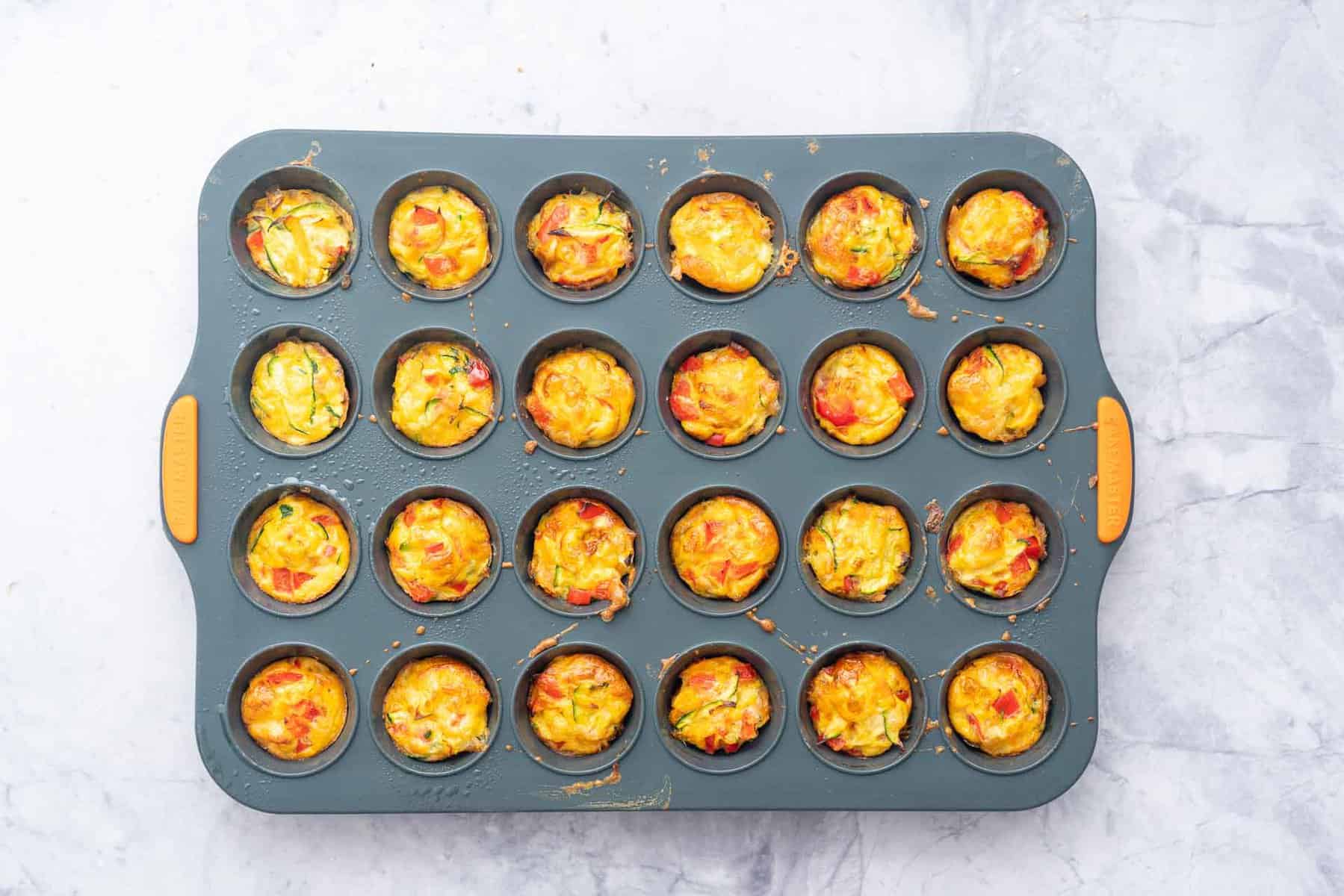 Mini muffin tray of cooked mini egg muffins.
