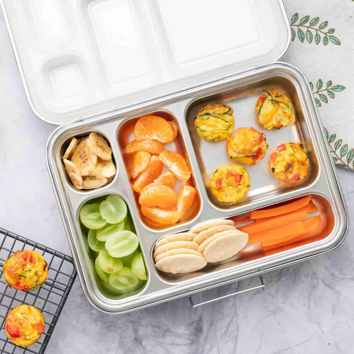 Egg muffins, fruits and veggies packed in a lunch box.