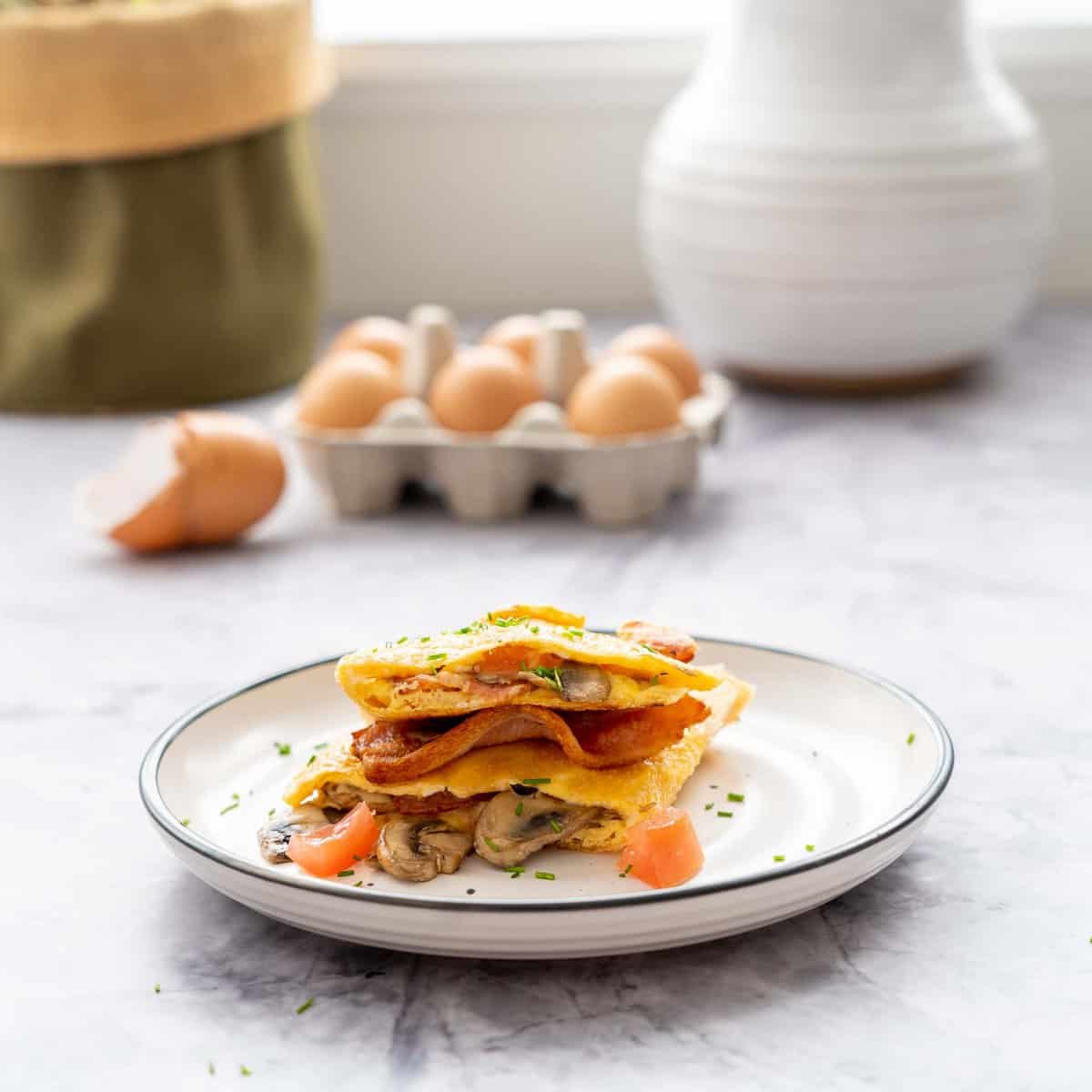 A rice paper omelette on a side plate on a marble bench top.