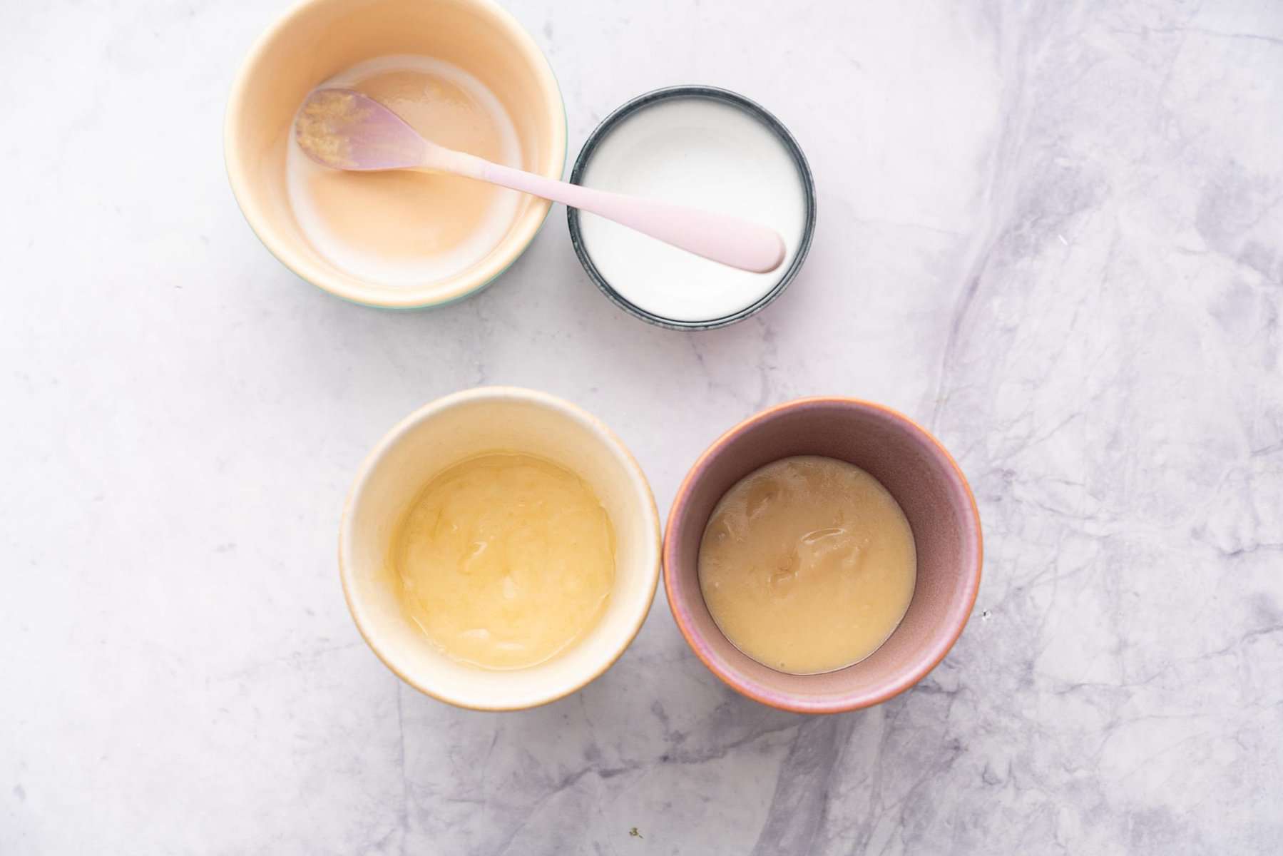 Emptied ramekins next to two mugs with half of the mixture divided into each.