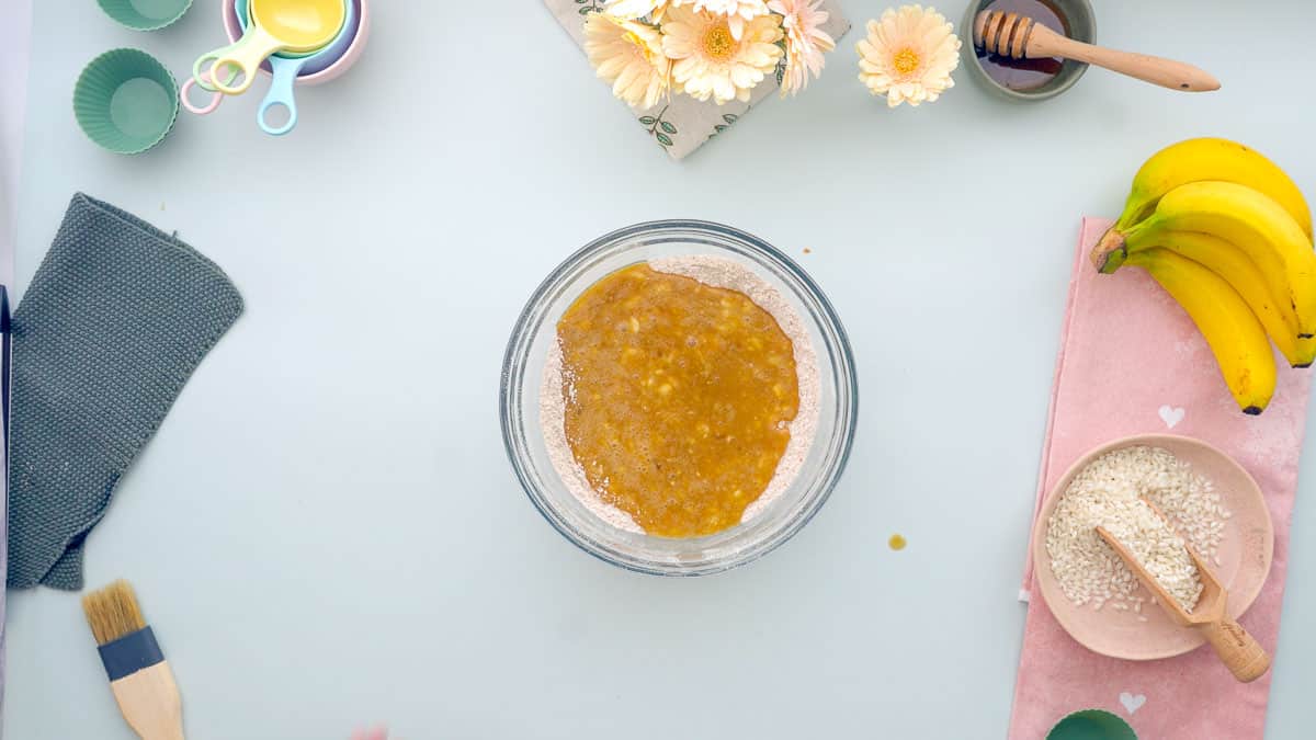 A mixing bowl containing wet nd dry ingredients before they are combined.