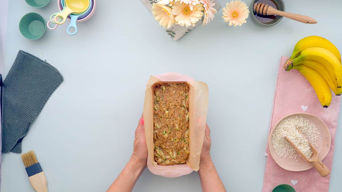 Banana zucchini bread batter in a pink silicone loaf tin ready to go into the oven.