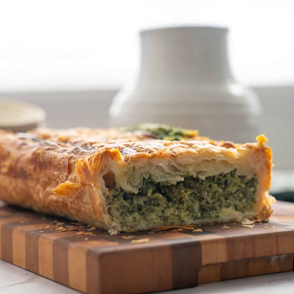 A pie with spinach filling cut into to show the vibrant green filling.