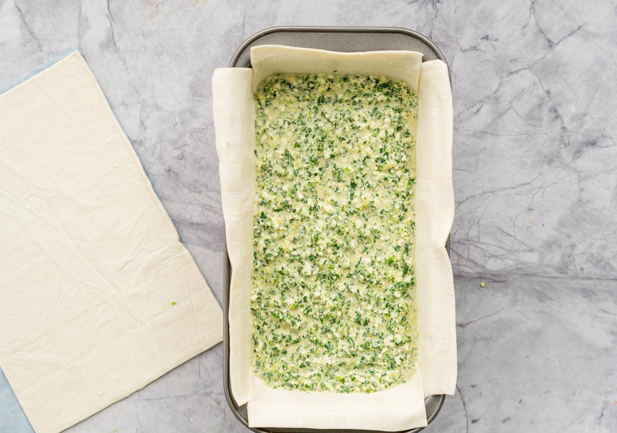 Spinach and cheese filling in a puff pastry lined loaf tin.
