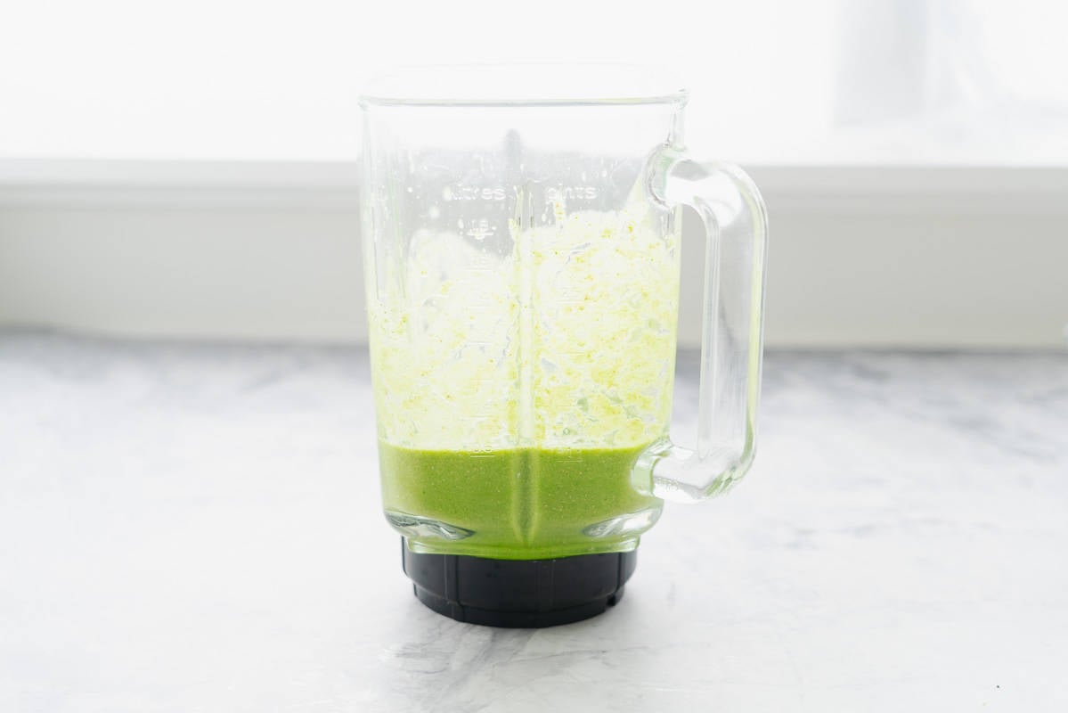 All the ingredients whizzed together to make the Spinach Smoothie in a blender sitting on the bench