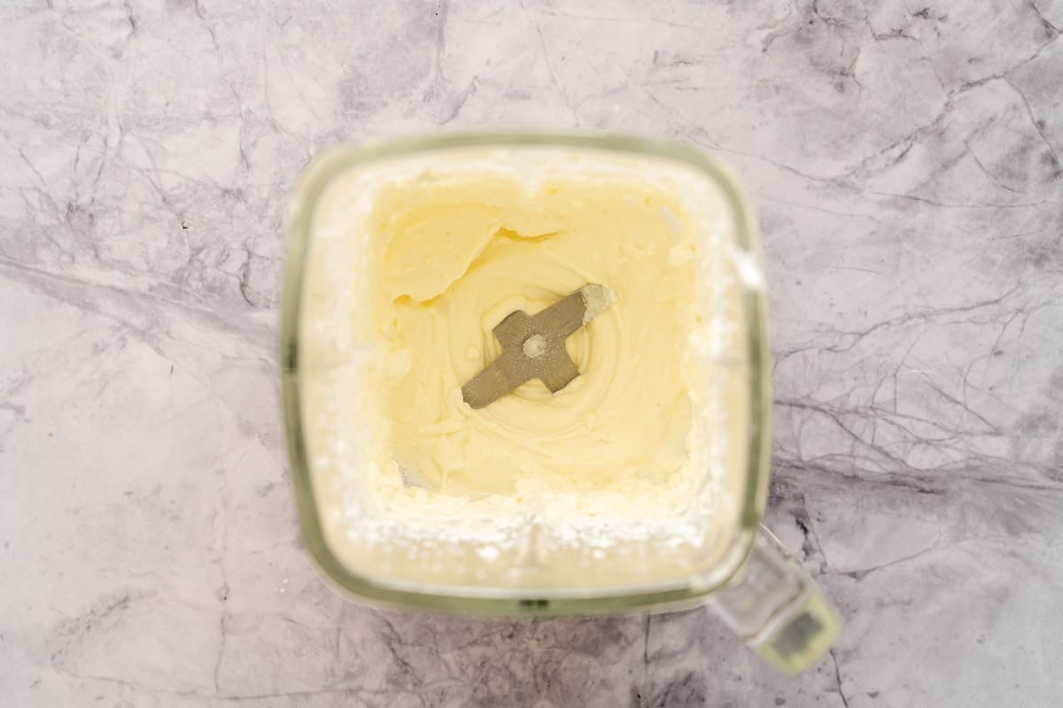 A blender full of whipped cottage cheese sitting the bench