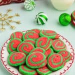 Green and red pinwheel cookies stacked on a serving plate.