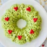 A large green krispie christmas wreath with red decorations on top.
