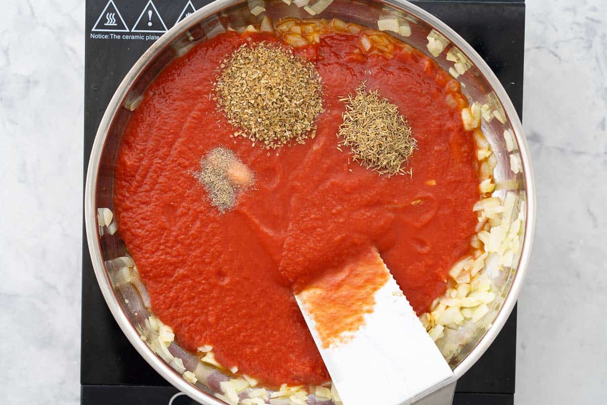 Passata, Oregon and thyme added to the frying pan of onions and garlic
