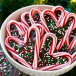 Candy canes in a bowl together shaped as hearts.