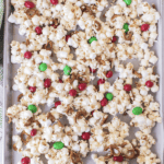 Popcorn laid on a tray with green and red lollies spread throughout.