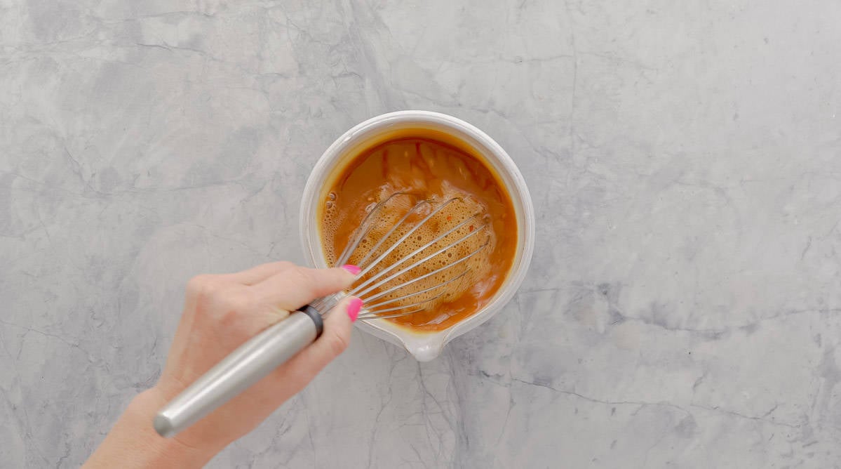 Honey, soy sauce, garlic, lemon juice and chilli flakes being mixed together.
