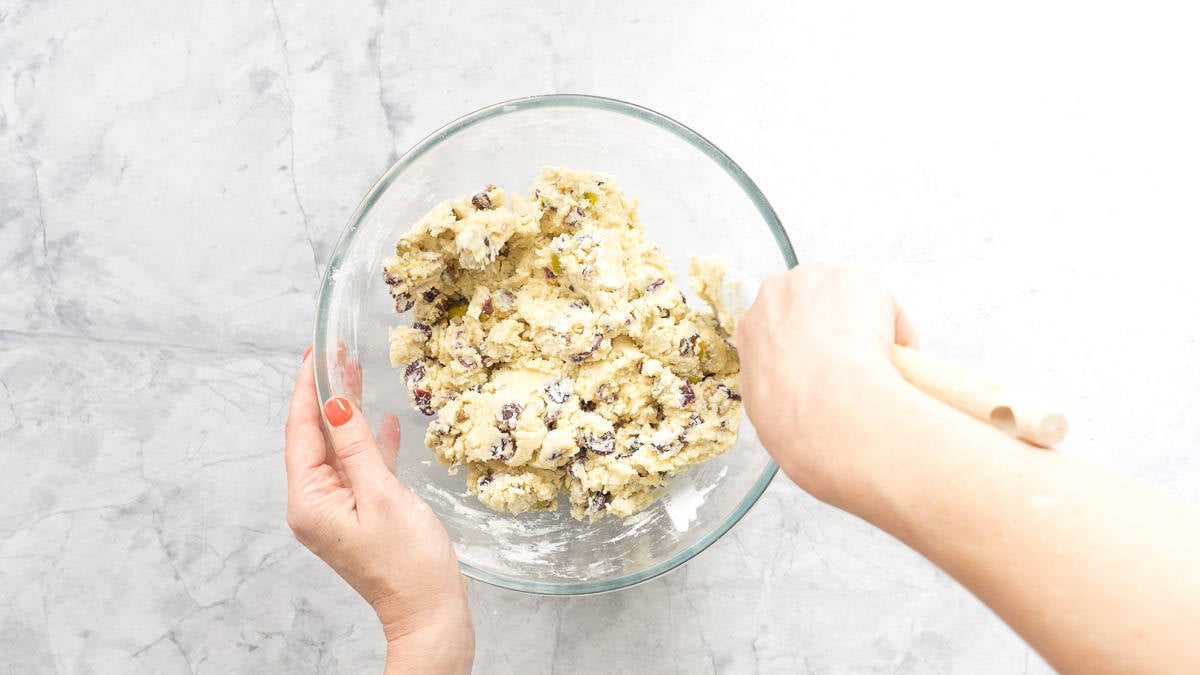 Cookie dough studded with pistachio and cranberries in a mixing bowl