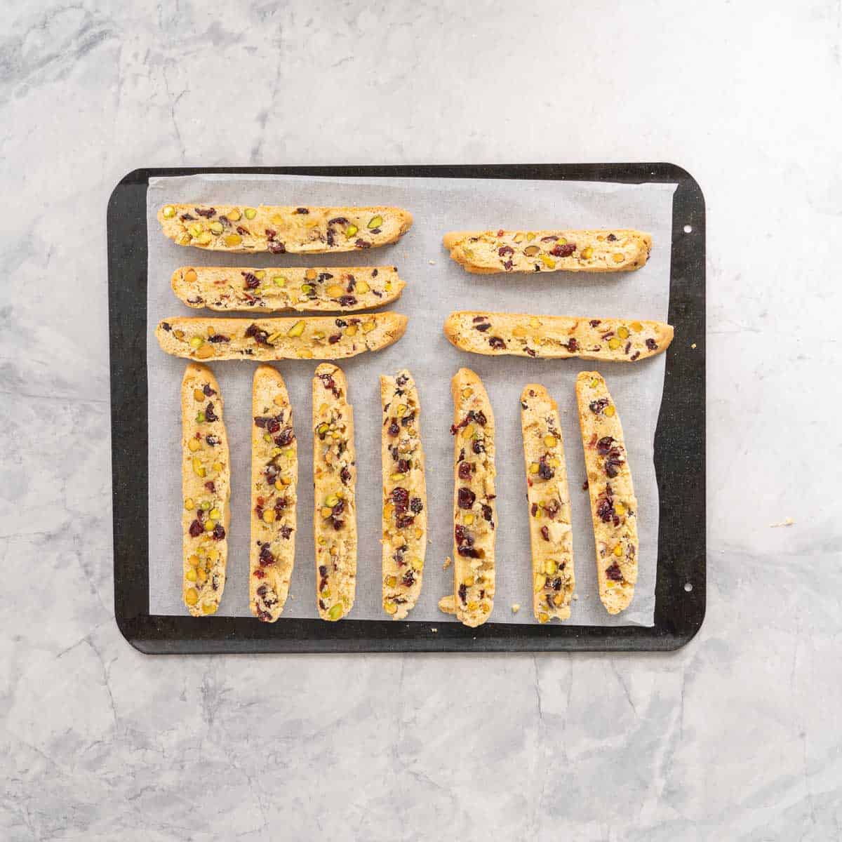 Fingers of biscotti laid out on a lined cookie sheet ready to bake.