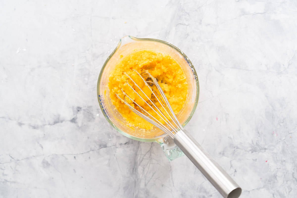 Whisked egg yolks, cornflour and sugar in a glass jug resting on the bench