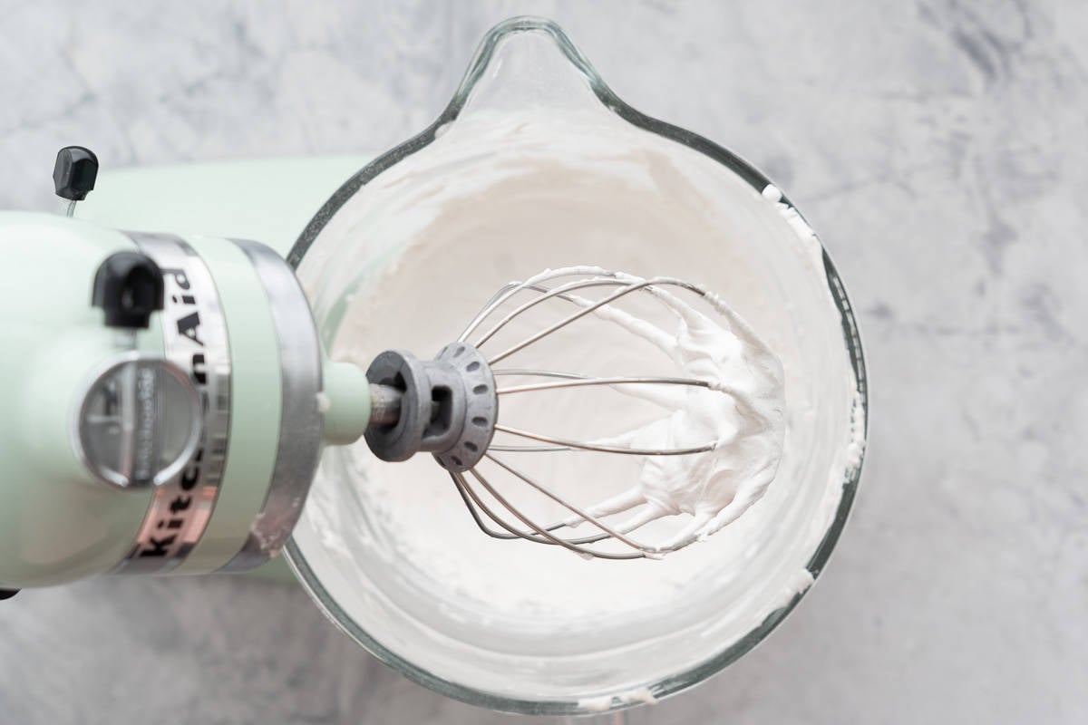 White and glossy aquafaba beaten with sugar to form meringue