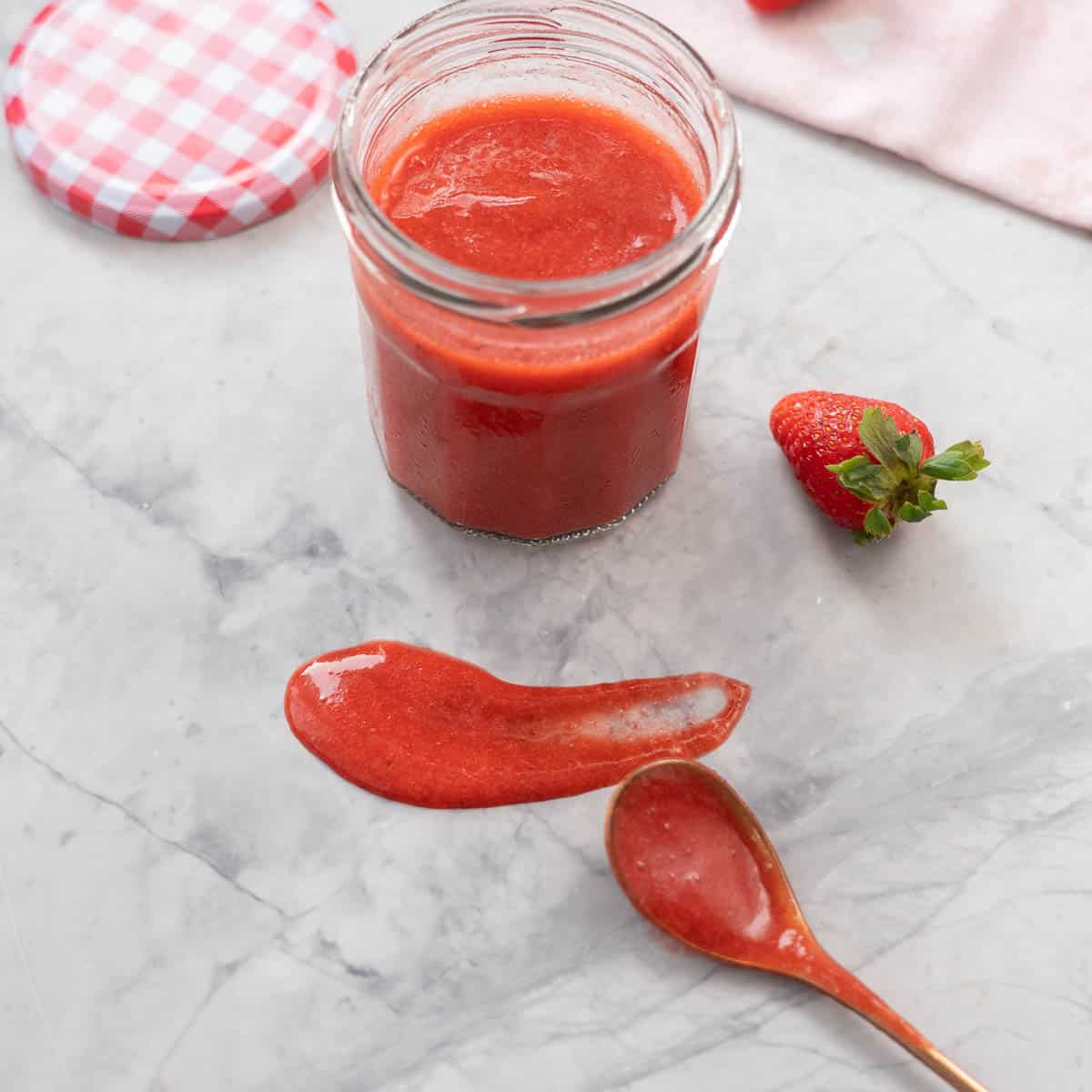 Red fruit puree smeared on a marble bench top.