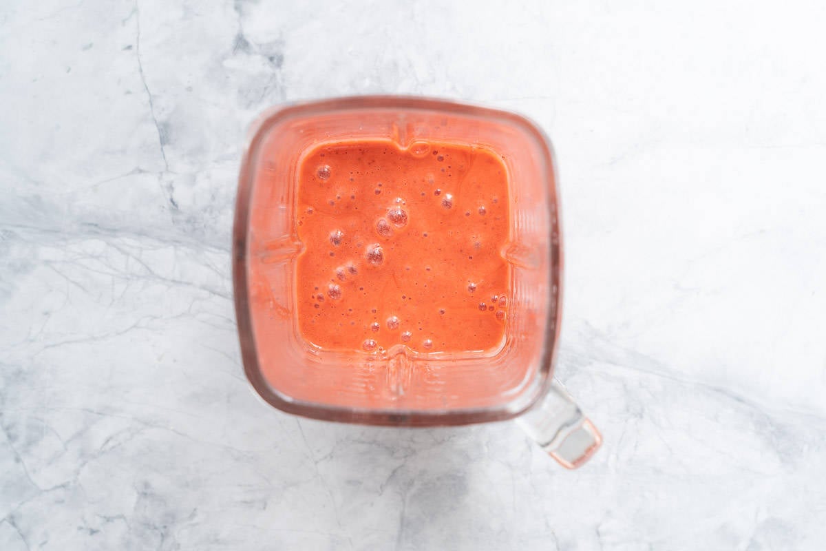 Smooth strawberry smoothie in a glass blender jug