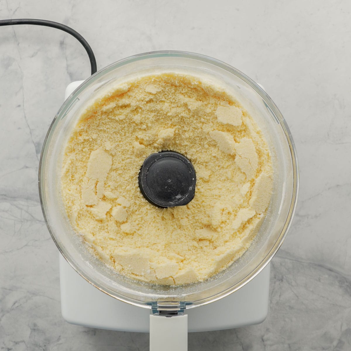 A food processor sitting on the bench with the ingredients inside whizzed together