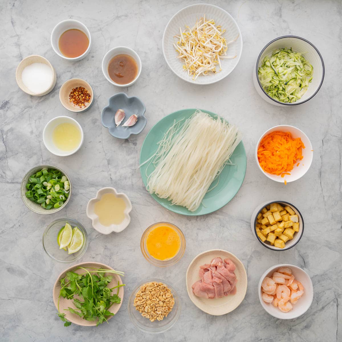 Ingredients to make a pad Thai stir fry laid out on a bench top.