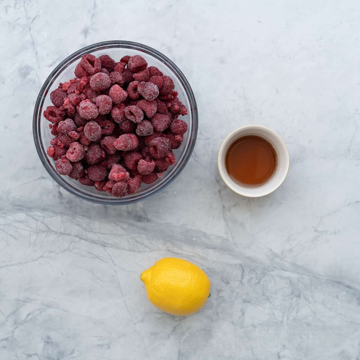 All the ingredients to make the raspberry puree laid out on the bench