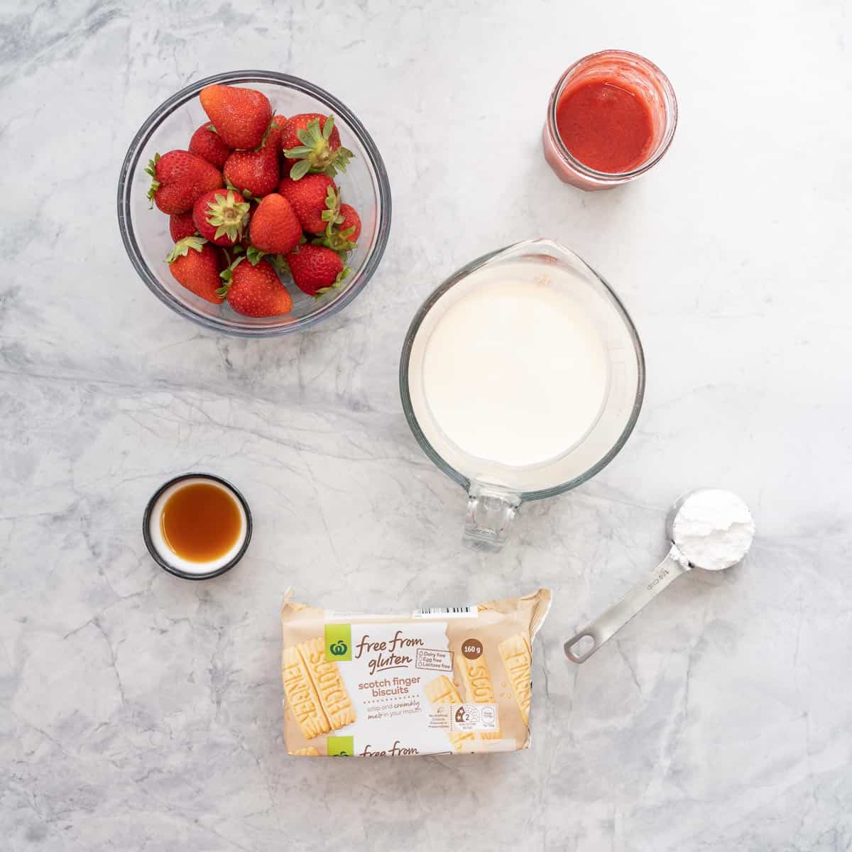 Ingredients for strawberry shortcake laid out on bench.