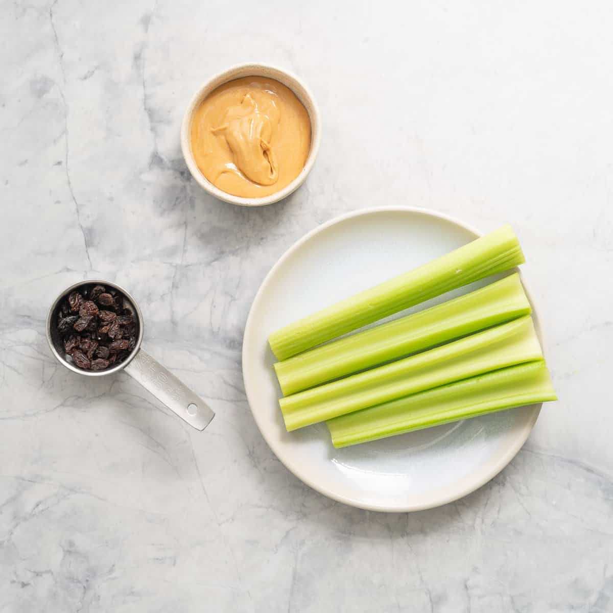 All the ingredients to make the ants on a log laid out on the bench