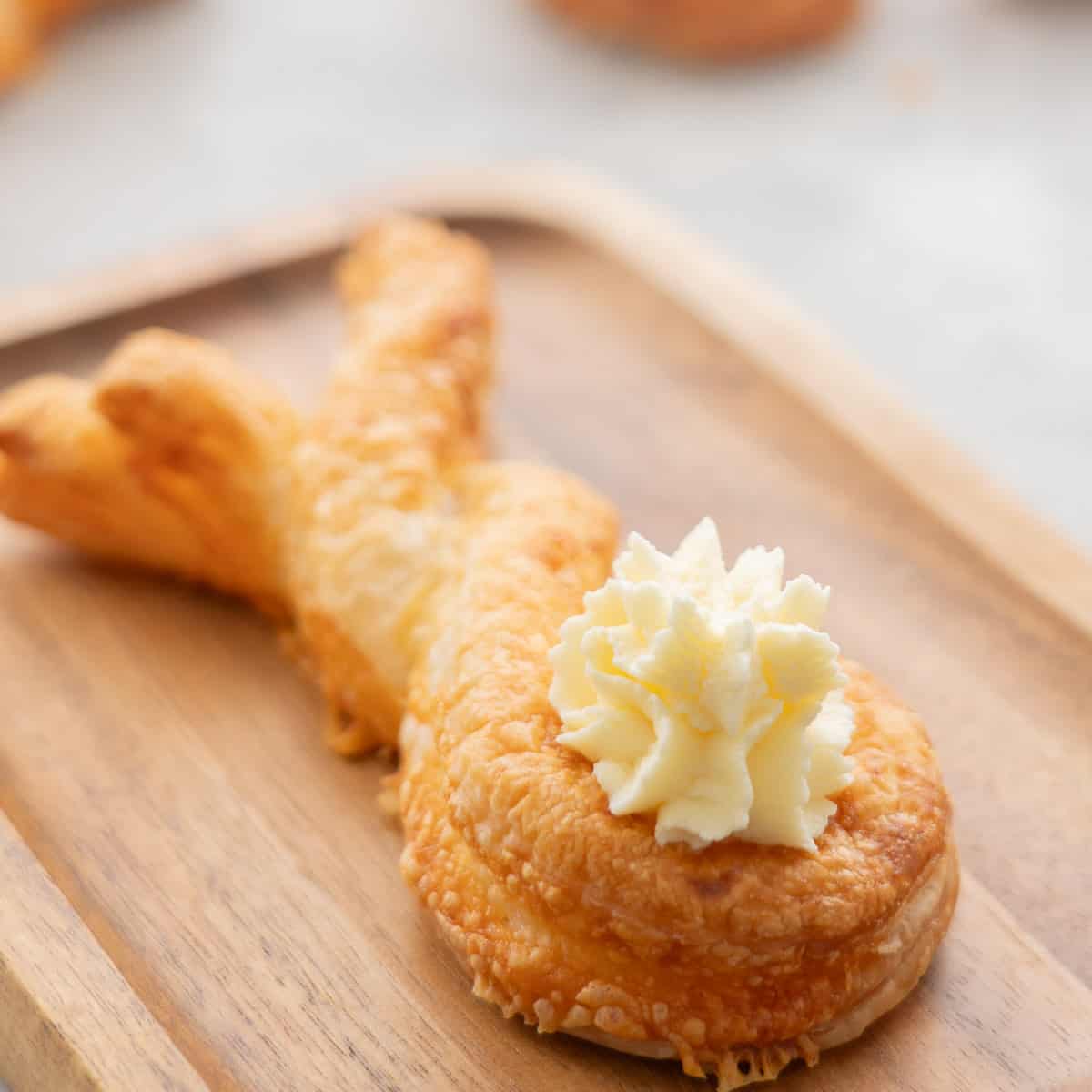 A close up of a cream cheese tail on a puff pastry bunny shape.
