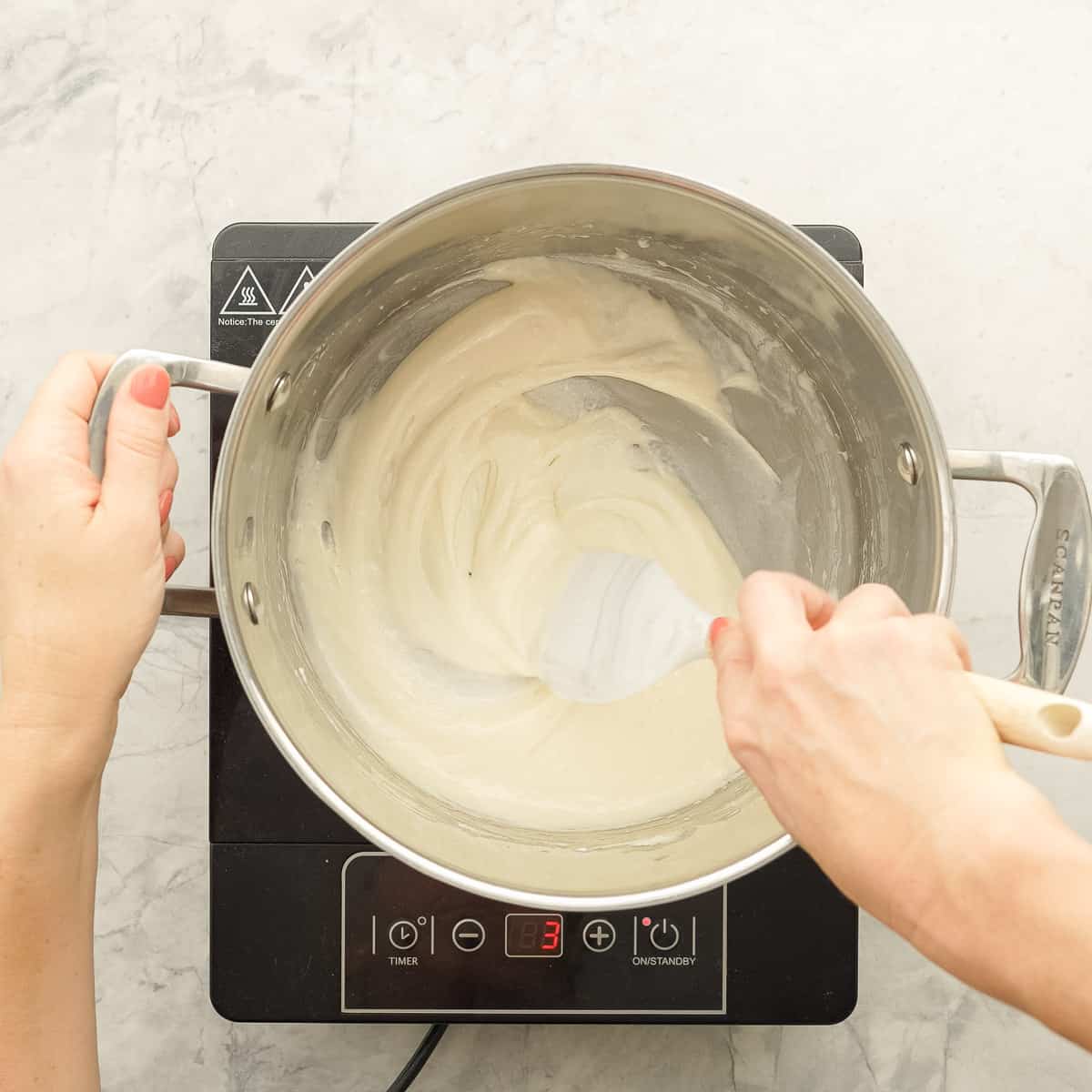 A large sauce pan of a white melted marshmallow mixture.