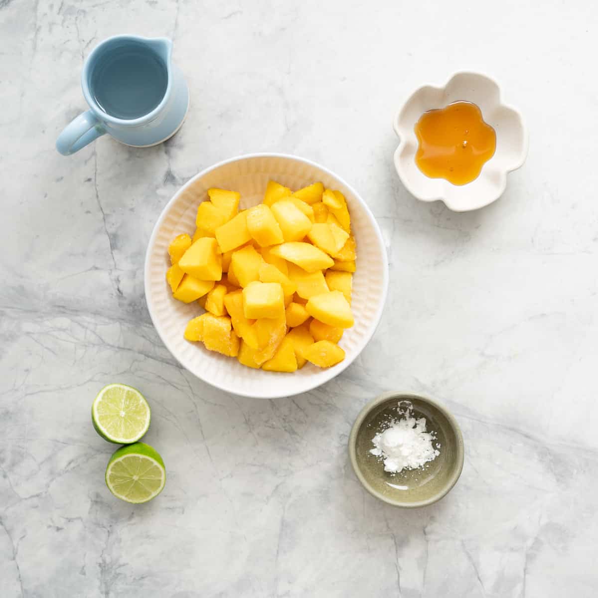 All the ingredients to make the mango popsicle laid out on the bench,