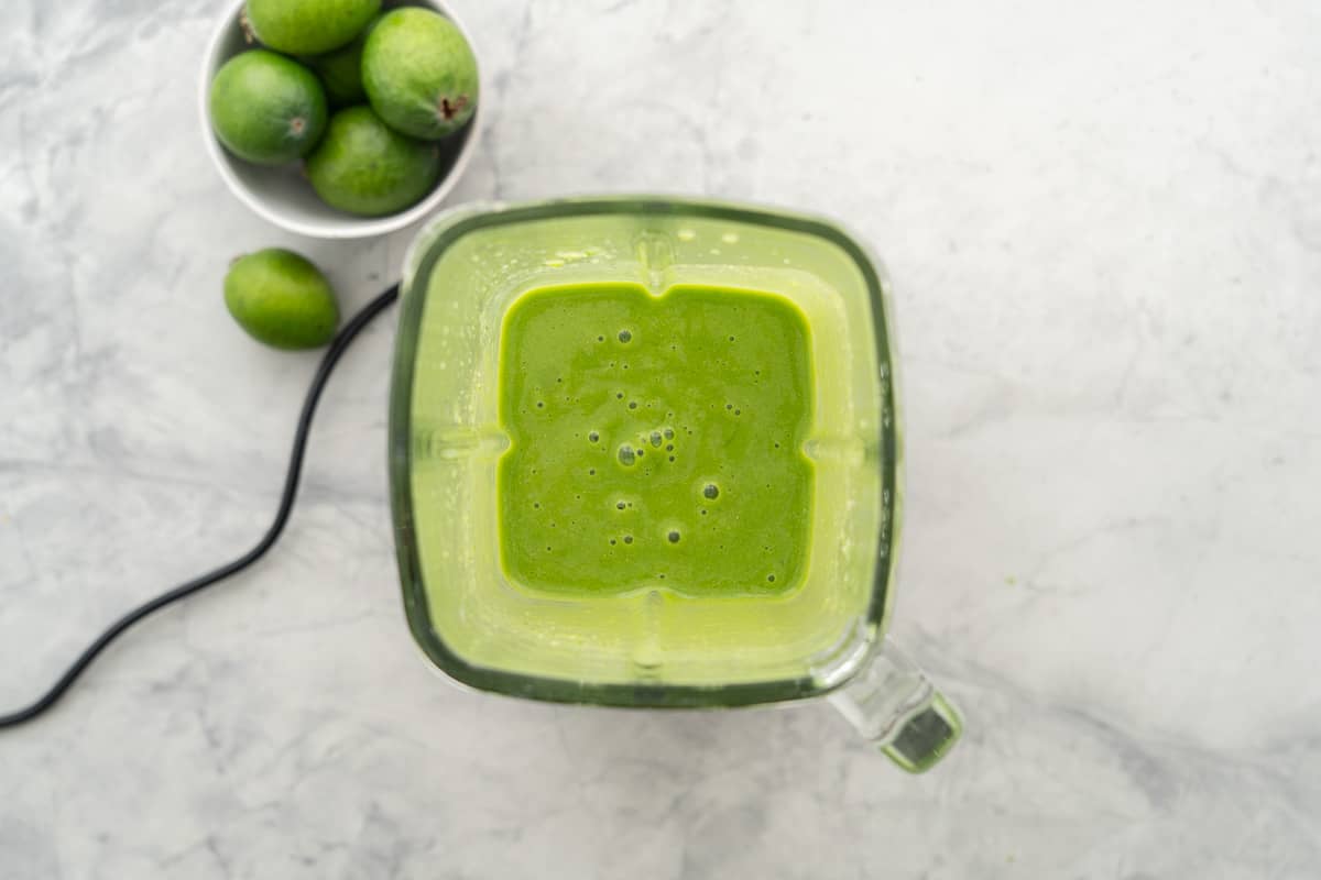 Thick green smoothie in a blender jug.
