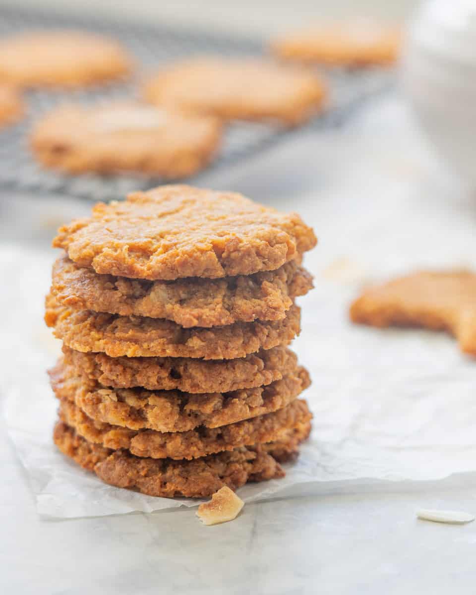 Seven cookies staked in a tower on a piece of crinkled parchment paper.