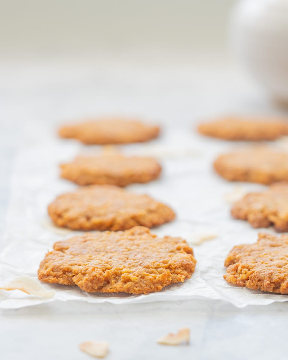 Close up of a golden Anza biscuit on a piece of crinkled parchment paper.