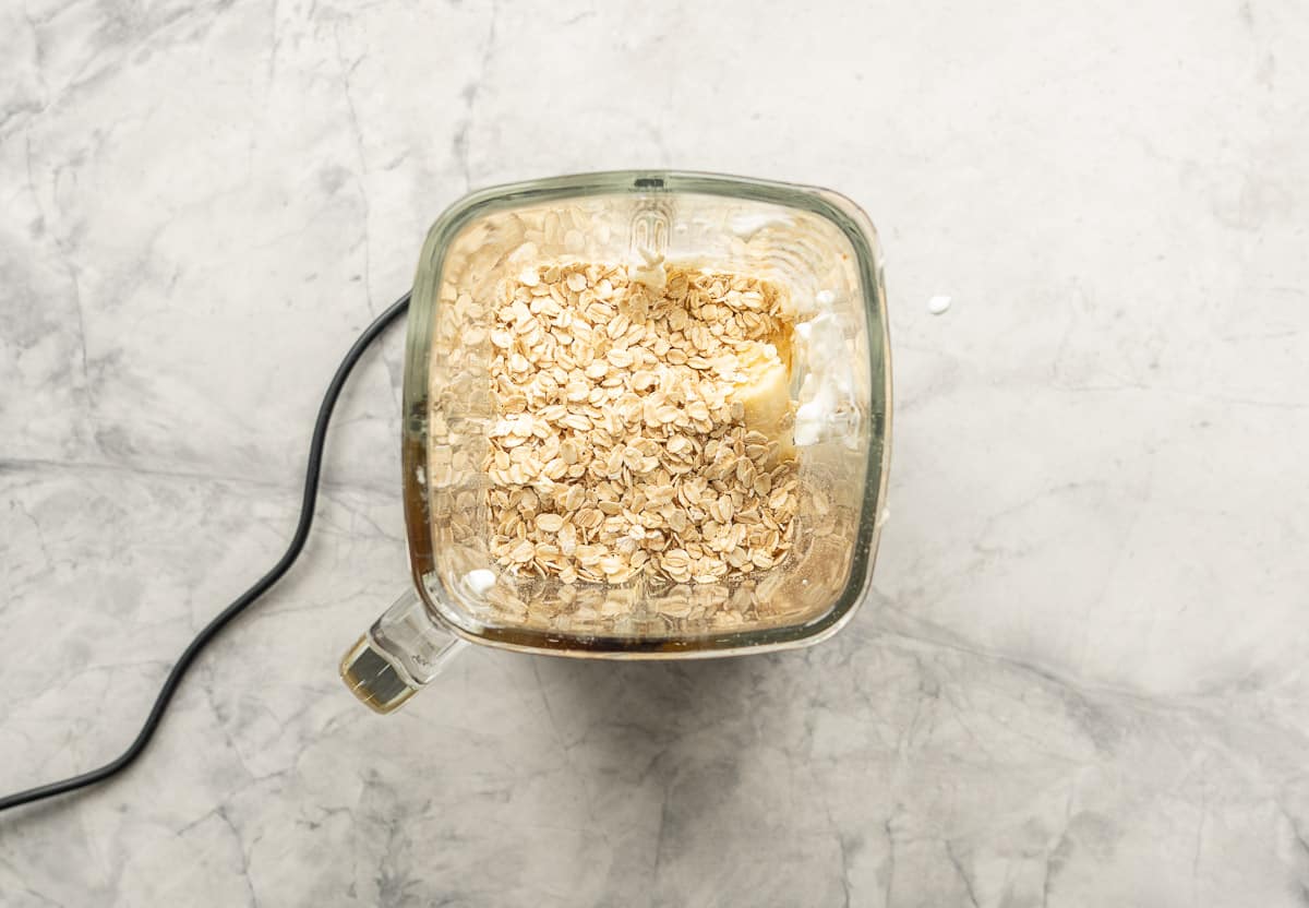 Ingredients for blueberry muffins in smoothie blender before being blended.