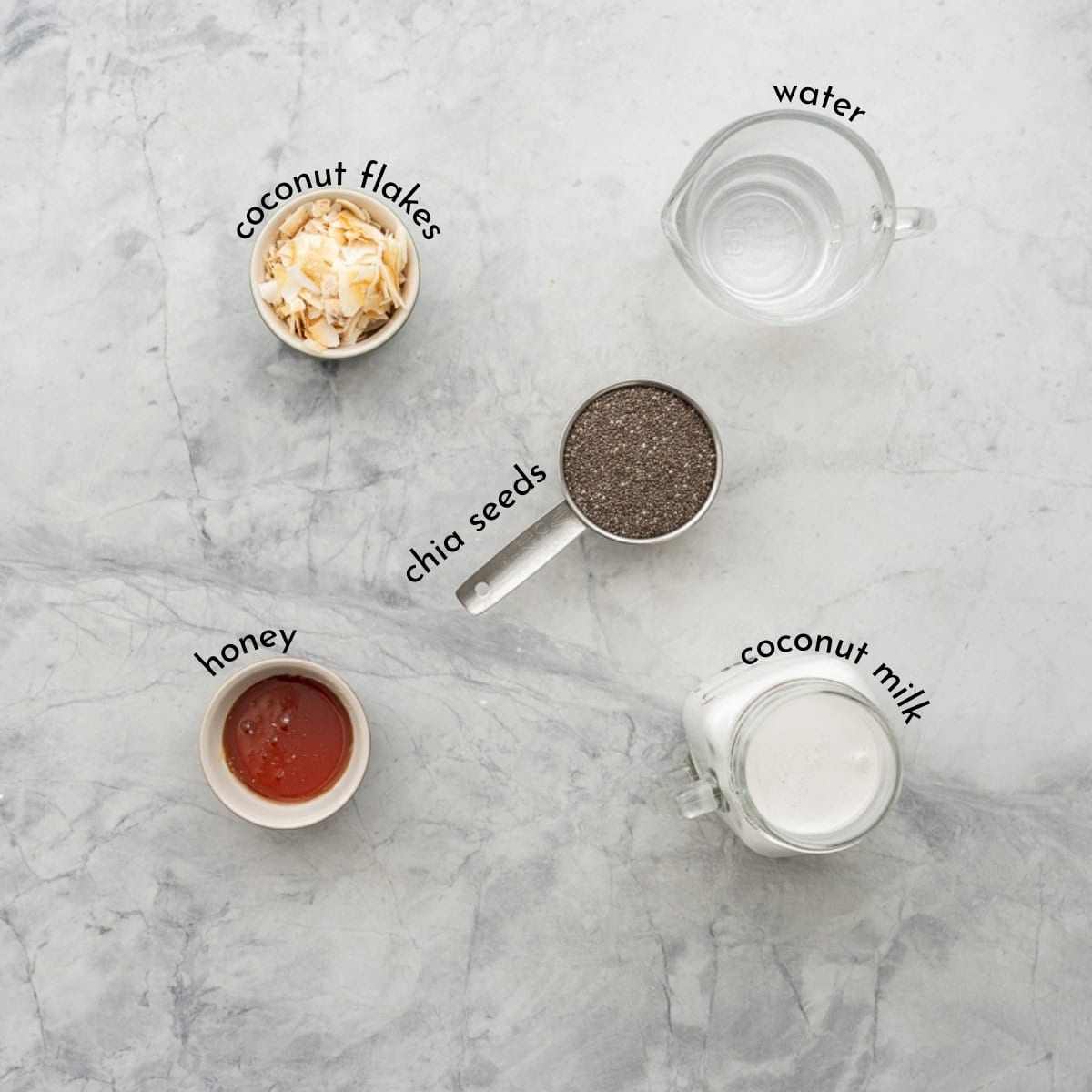 Ingredients for Coconut Chia Pudding on bench top with text overlay.