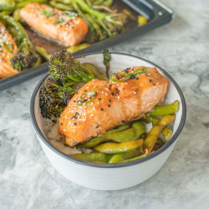 Bowl on bench top with cooked rice, vegetables and salmonon top.
