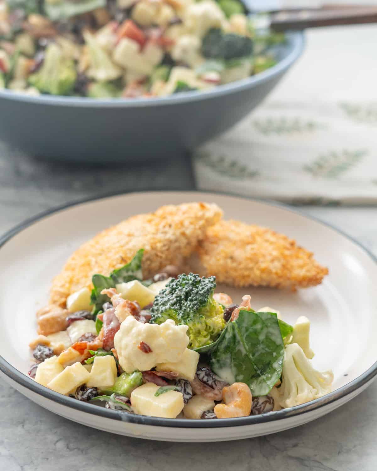A plate with crumbed chicken and a cauliflower salad.