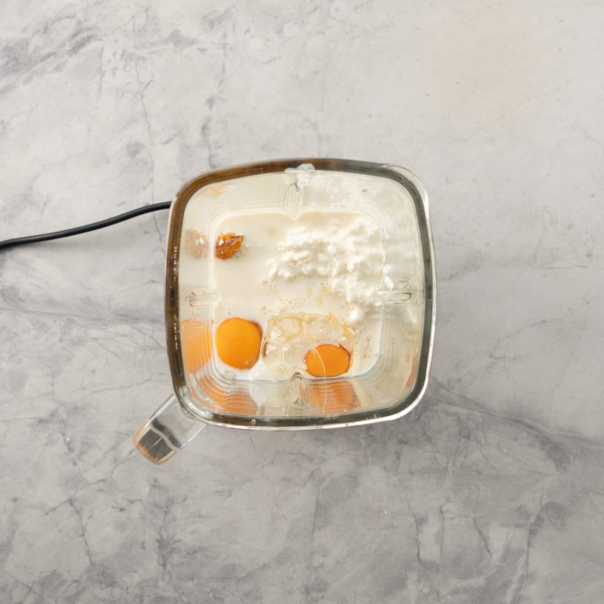 eggs, milk, cottage cheese and pumpkin in a blender jug.