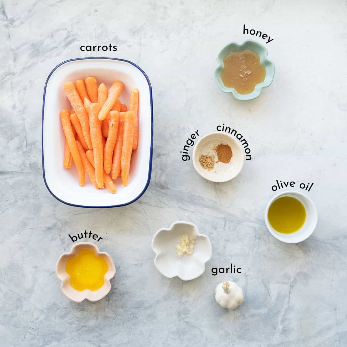 ngredients for honey glazed carrots portioned in small dishes laid out on bench top with text overlay.
