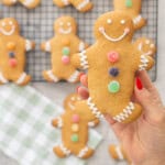 GF Gingerbread held up to the camera decorated with three colourful circle jellys down the centre, royal icing squiggly lines on feet and arms, smiley face.