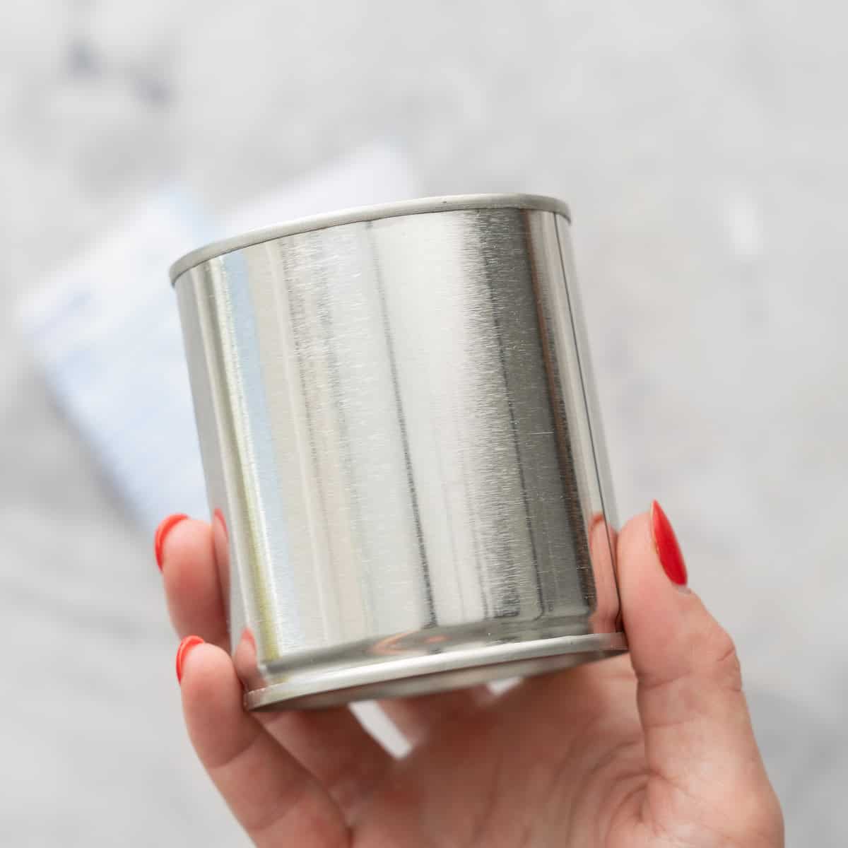 Sweetened condensed milk can held up to camera with label removed.