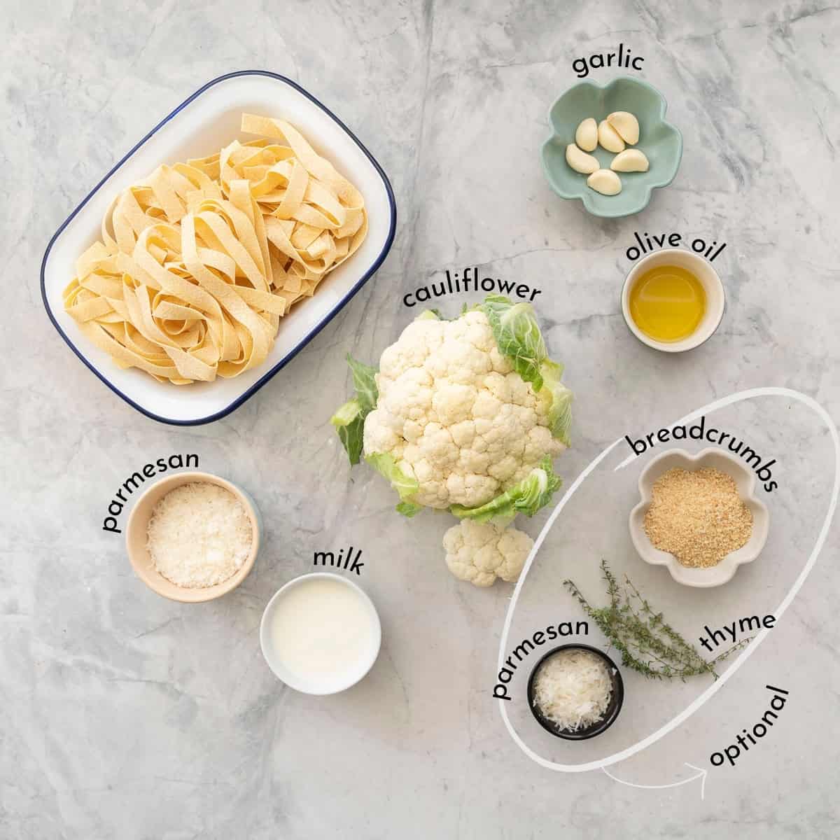 Ingredients for cauliflower alfredo on benchtop with text overlay.