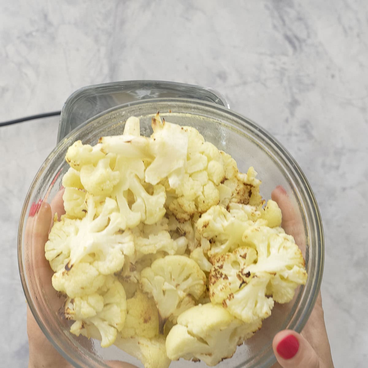 Glass bowl with cooked slightly roasted cauliflower.