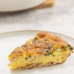 Slice of quiche on dinner plate.