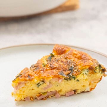 Slice of quiche on dinner plate.