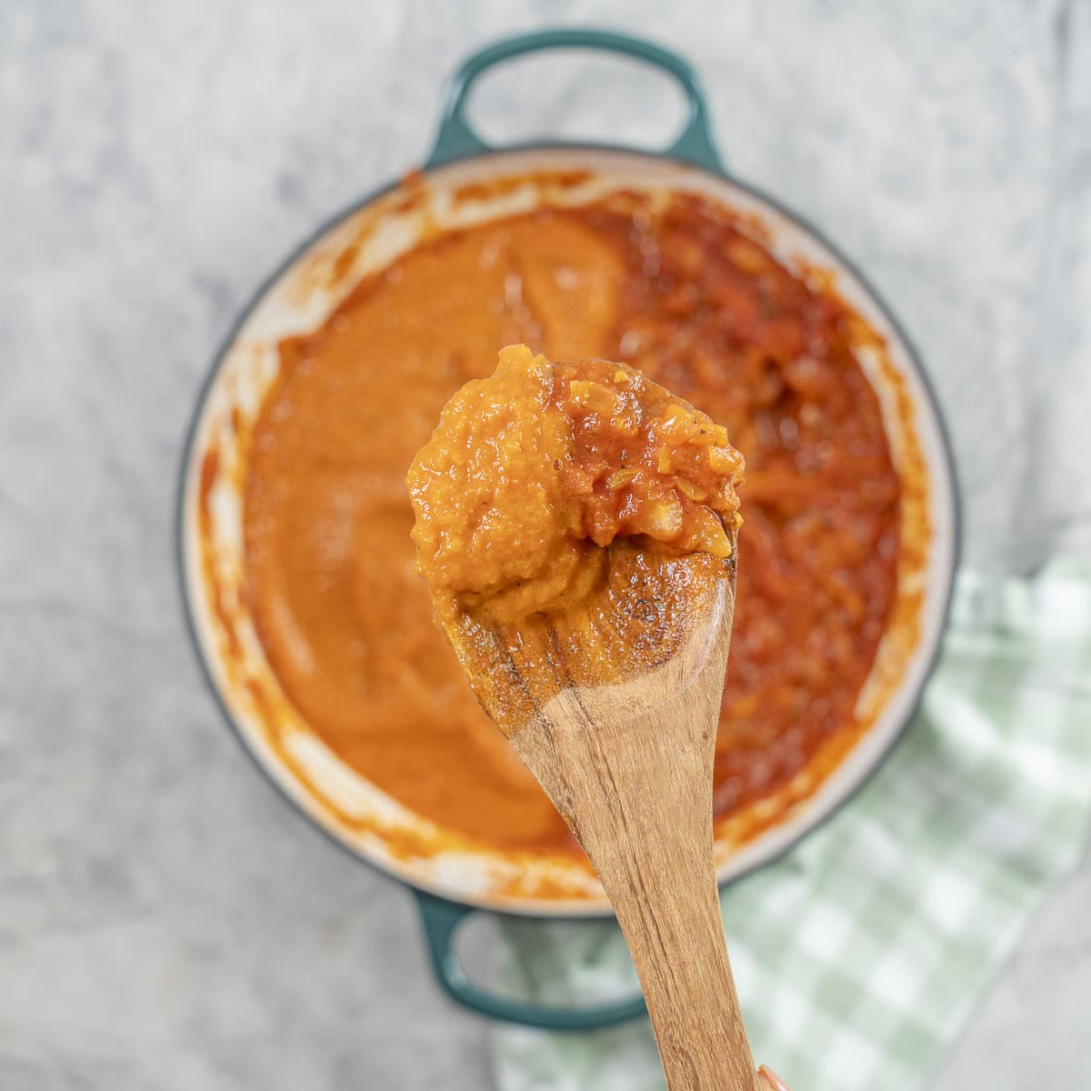 Smooth and chunky marinara sauce on a wooden spoon.
