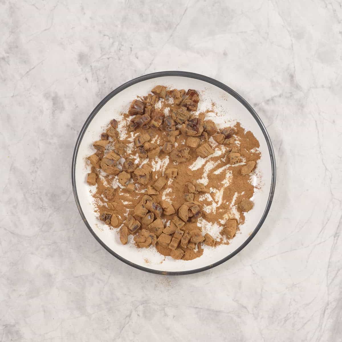 Cinnamon date mixture on a plate on bench top.