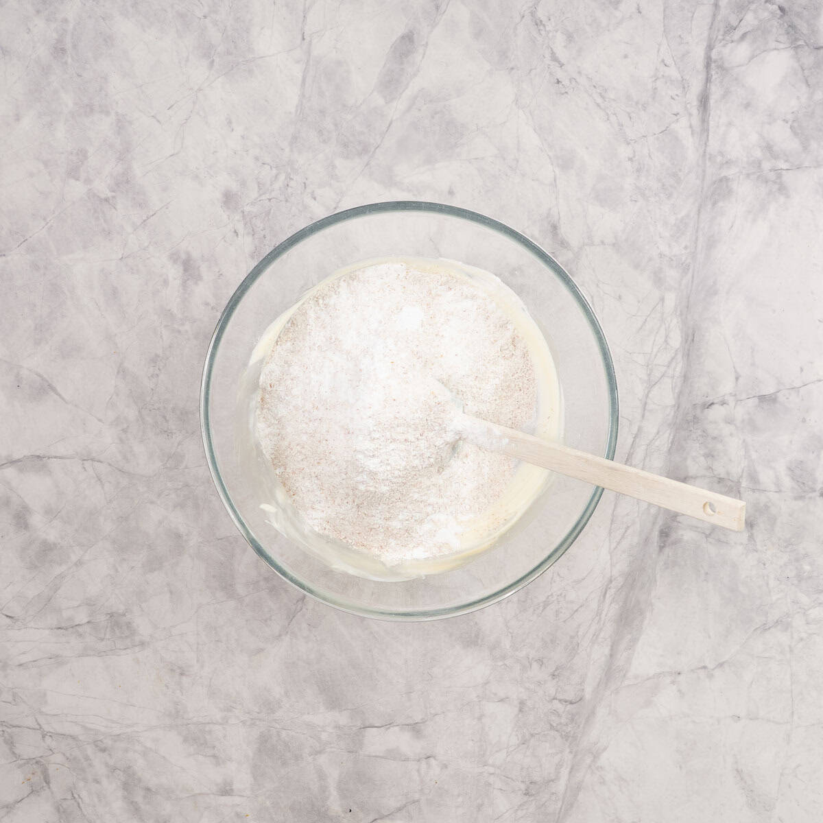 Flour, baking powder, and salt added into large bowl of yogurt, maple syrup and vanilla.